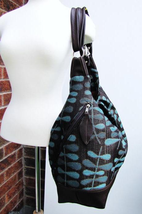 XL turquoise/brown canvas with leather straps, base, and zipper top closure, convertible 3 way bag